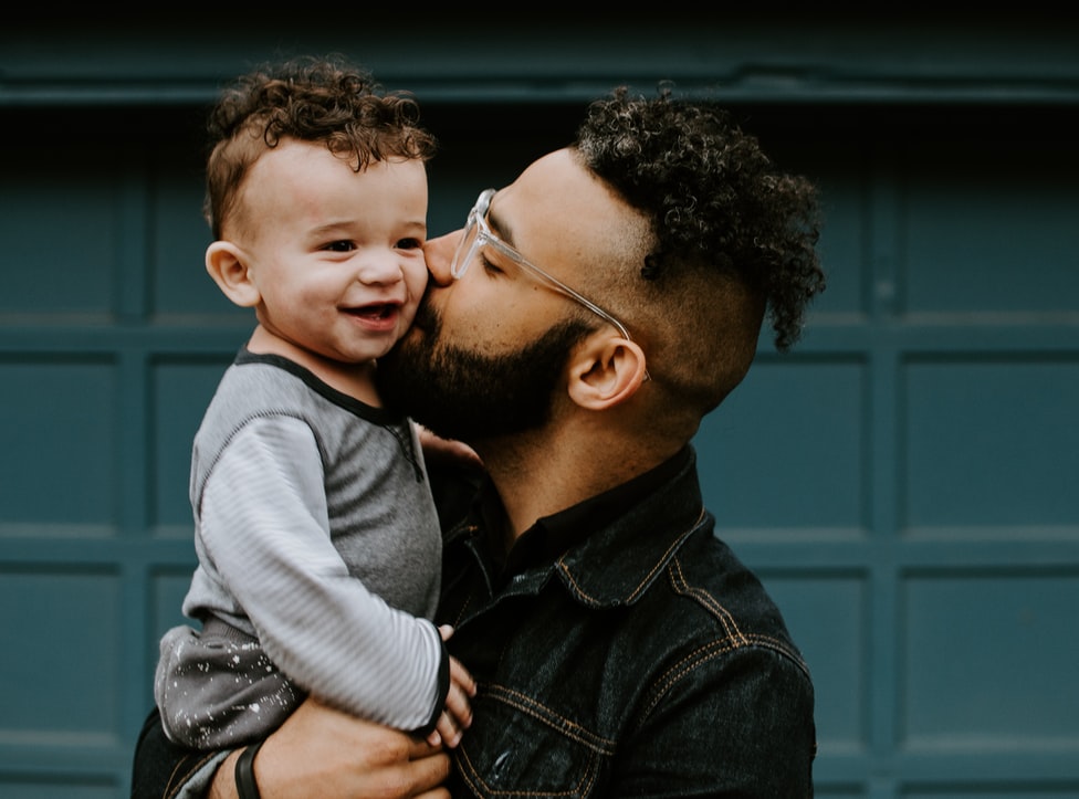 father kissing his son