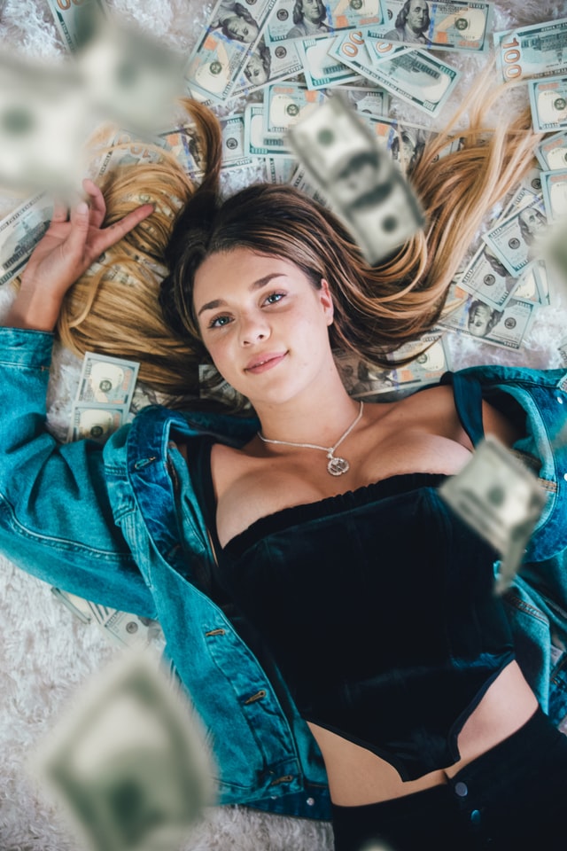 a girl lying on top of money