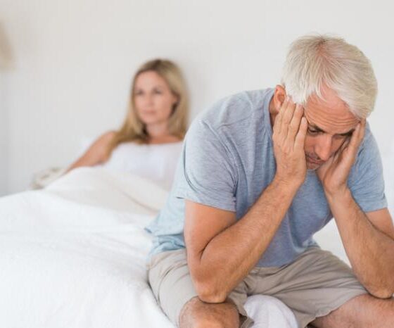 man-sitting-on-the-edge-of-bed-looking-troubled